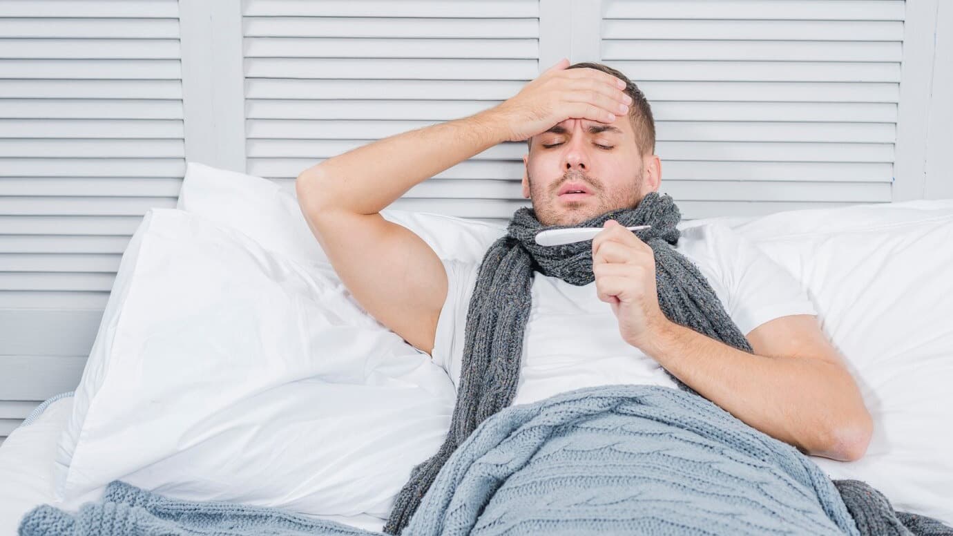 portrait-young-man-lying-bed-checking-his-fever-thermometer_23-2147948490.jpg